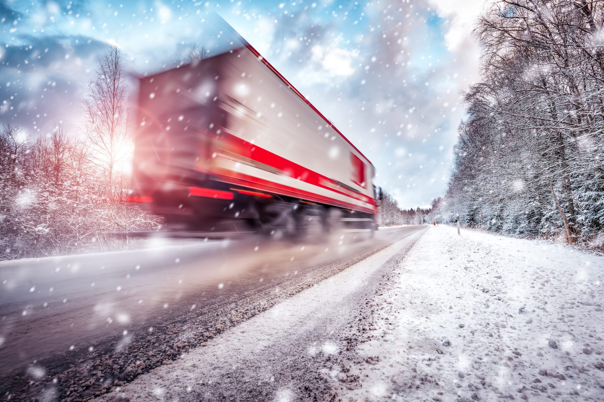 A semi-truck moving along a snow-covered road during winter weather, representing holiday freight shipping and seasonal delivery challenges.