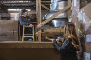 Warehouse storage solutions with workers staging inventory and organizing pallets for efficient logistics operations